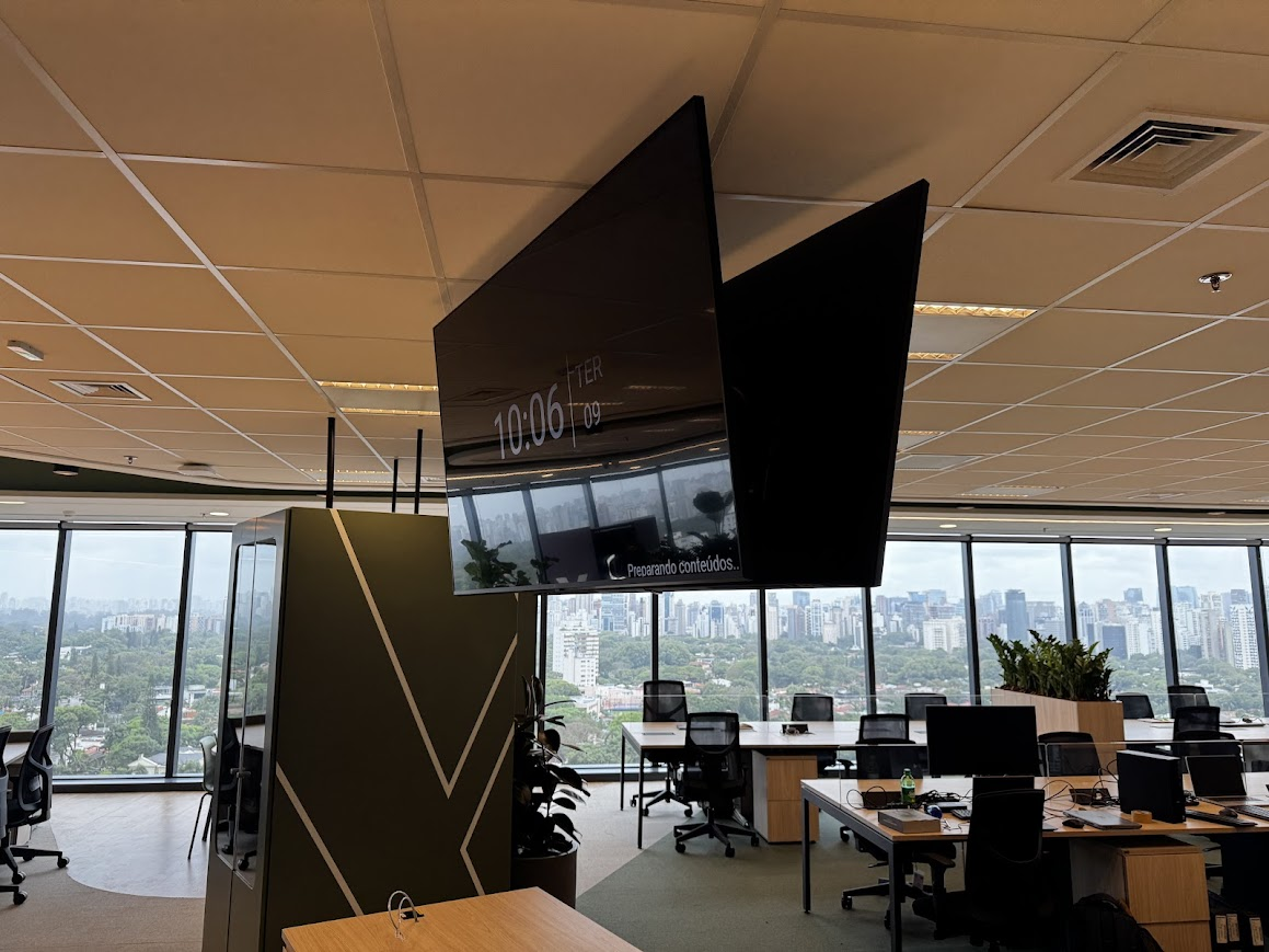 Dois displays corporativos instalados em suporte suspenso de teto
